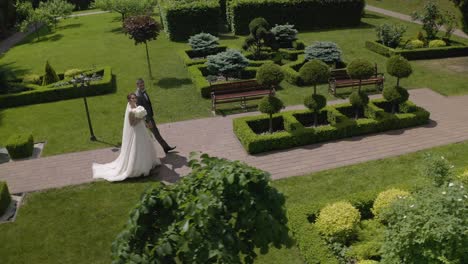 Lovely-newlyweds-caucasian-bride-groom-walking-in-park,-holding-hands,-wedding-couple-family