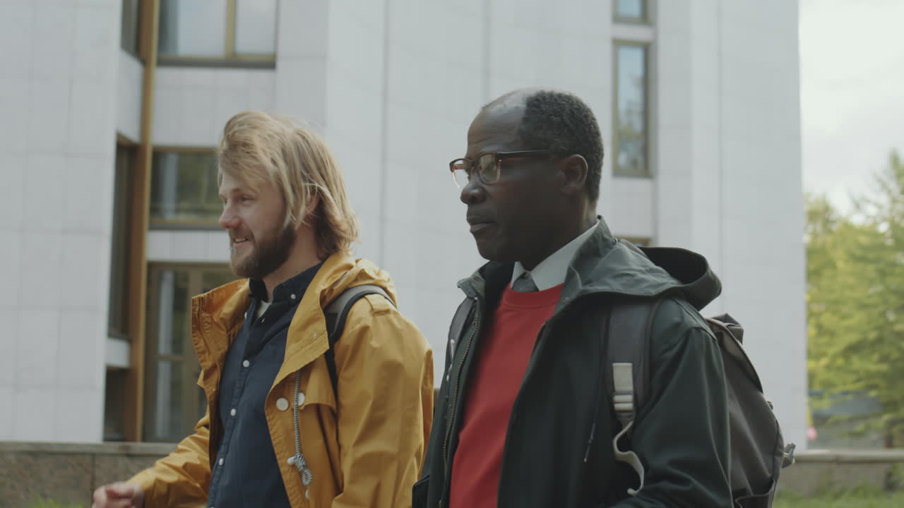 Two diverse men walking and conversing outdoors