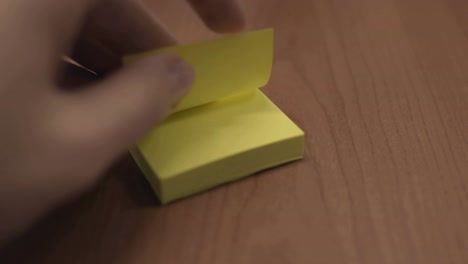 tirando de una hoja amarilla de post-it