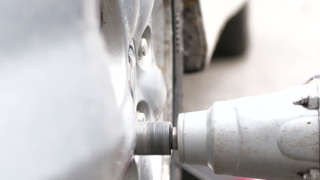 Super-close-up-of-screwdriver-in-changing-a-tire-Ground-level-and-static-view