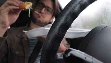 slow motion young driver man eating fried cheese in his car