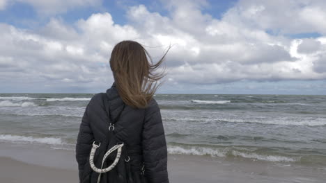 cinematic shot of woman admiring the ocean in slowinski national park, poland