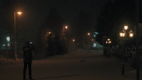 Hombre-Disparando-Con-Móvil-En-El-Parque-Nocturno-De-Invierno