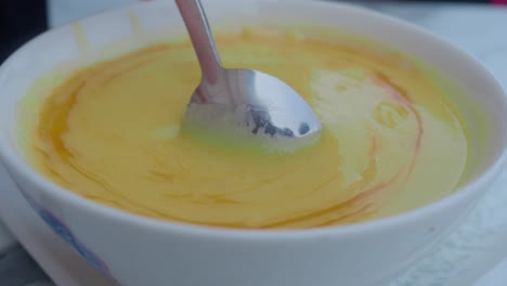 eating creamy yellow soup