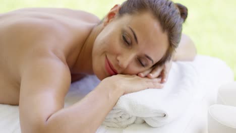 Close-up-of-woman-with-brown-hair-relaxes-on-table