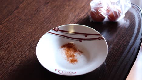 Pouring-Cumin-Powder-And-Cracked-Three-Fresh-Eggs-Onto-Plate