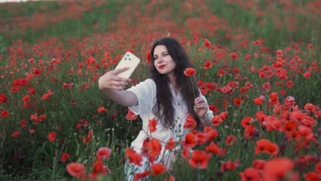 woman taking selfies in a vibrant poppy field