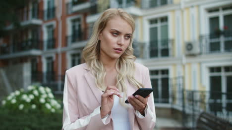 Porträt-Einer-Frau,-Die-Ihr-Smartphone-Auf-Der-Straße-Benutzt.-Frau-Geht-Mit-Telefon-In-Der-Hand