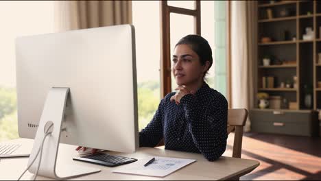 mujer india usando computadora analizando estadísticas, preparando informes financieros