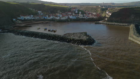 pullback establishing aerial shot of staithes coastal village uk