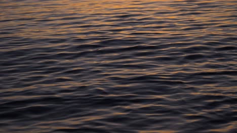 reflection of sunset on calm ocean water in slow motion