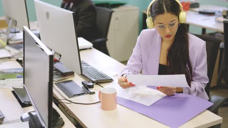 concentrated woman reading a financial report in a coworking space