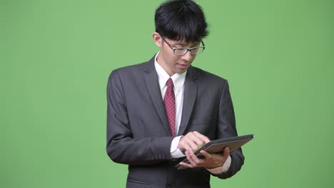 joven empresario asiático usando una tableta digital
