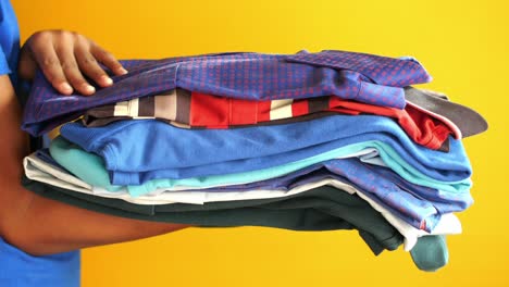 person holding a stack of folded clothes