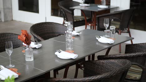 Cutlery-and-empty-plate-on-table-against-cafe-background