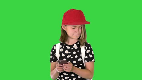 school girl checking her mobile phone on a green screen, chroma key