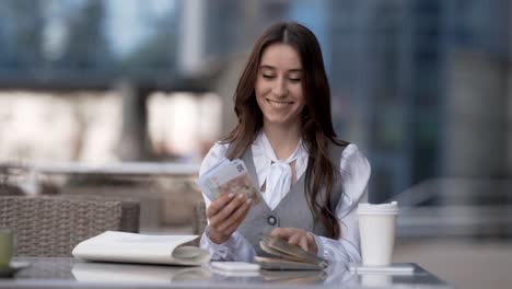 Una-Mujer-De-Negocios-Besa-Un-Fajo-De-Dinero-Y-Lo-Esconde-En-Un-Bolso