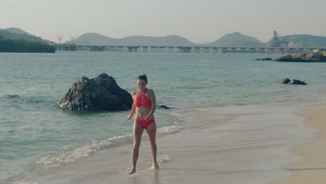 Una-Chica-Elegante-En-Bikini-Corre-Dando-Vueltas-En-La-Línea-De-Surf