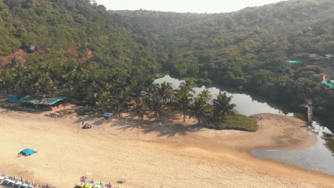 lago de agua dulce cerca de la costa del océano en arambol beach resort, en goa, india - órbita aérea de ángulo bajo