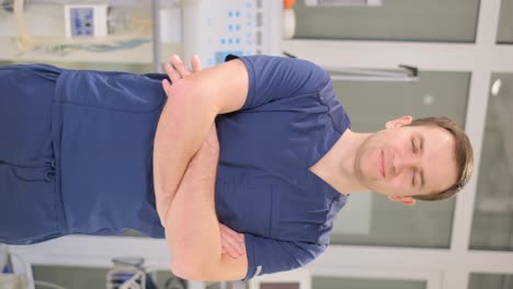 vertical portrait of a young doctor looking at the camera while standing in a modern clinic. free medicine in europe. vertical video
