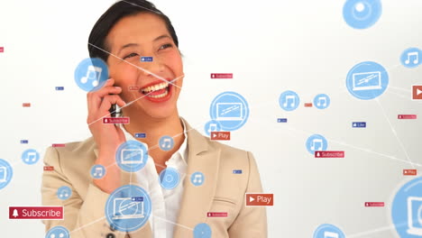 animation of digital, social media icons over biracial businesswoman talking on smartphone at office