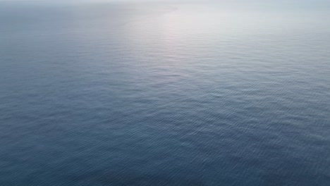 drone shot panning up to reveal a sunset over the mediterranean sea