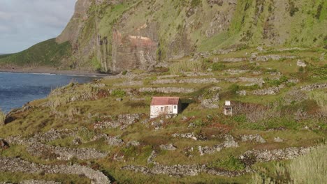 Toma-Panorámica-Lateral-De-Una-Antigua-Casa-Cerca-Del-Mar-En-La-Isla-Flores,-Aérea