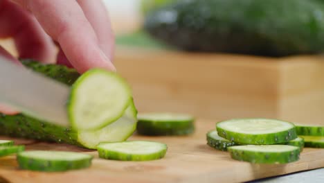 men hands cut cucumber on a cutting board.