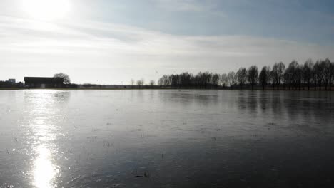 Reflejo-De-La-Luz-Del-Sol-A-Través-Del-Río-Congelado-Desde-Hendrik-ido-ambacht-Cerca-Del-Parque-Sandelingen-En-Holanda-Del-Sur,-Países-Bajos