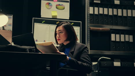 private agent studying criminal files and archived folders in incident room