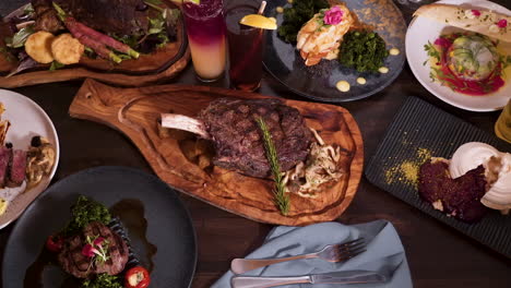 top down view tabletop full of elegantly plated dinner options at an expensive romantic steakhouse, birdseye view slider hd