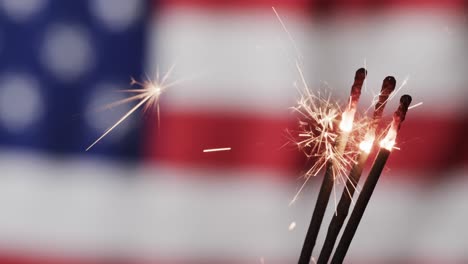 video of close up of sparklers with copy space over flag of usa