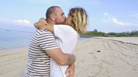 dulce pareja besándose y abrazándose en la playa