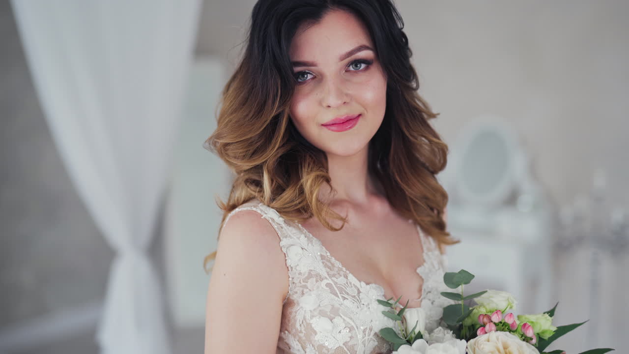 Wedding bouquet of creamy roses in the hands of a beautiful bride. Lovely young woman dressed in white wedding dress is holding flowers. Close-up.