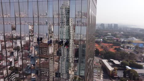 uncommon aerial drone view of window cleaners on buenos aires glassy skyscraper