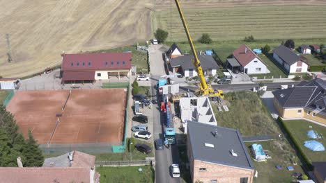 Mobile-crane-building-modular-house-at-suburban-construction-site