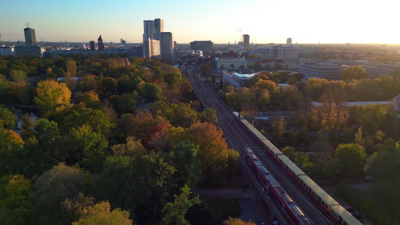 Aerial View of Berlin City with Train Tracks Running Through Autumn Park at Sunset
