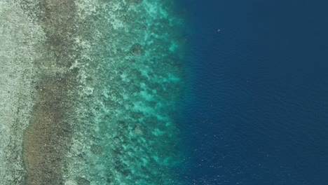 Vista-Aérea-De-Arriba-Hacia-Abajo-Sobre-El-Gradiente-Vertical-De-La-Orilla-Del-Mar-Agua-Limpia-Reflejada-Con-Tonos-Marinos-Amarillos-Dorados-Turquesas,-Arena-De-Playa-Blanca-Viajes-Al-Sudeste-Asiático