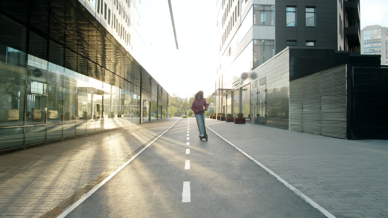 즐거운 아프리카계 미국인 부부가 거리에서 함께 전자 스쿠터를 타고 있습니다.