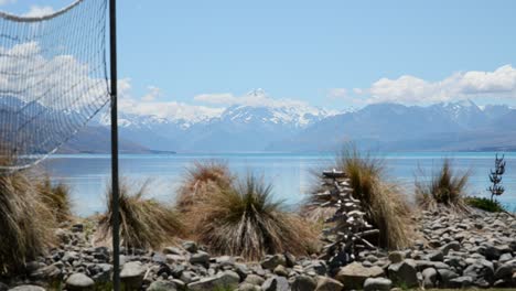 arbustos y una red de voleibol con snowy mount cook y blue lake pukaki en segundo plano.