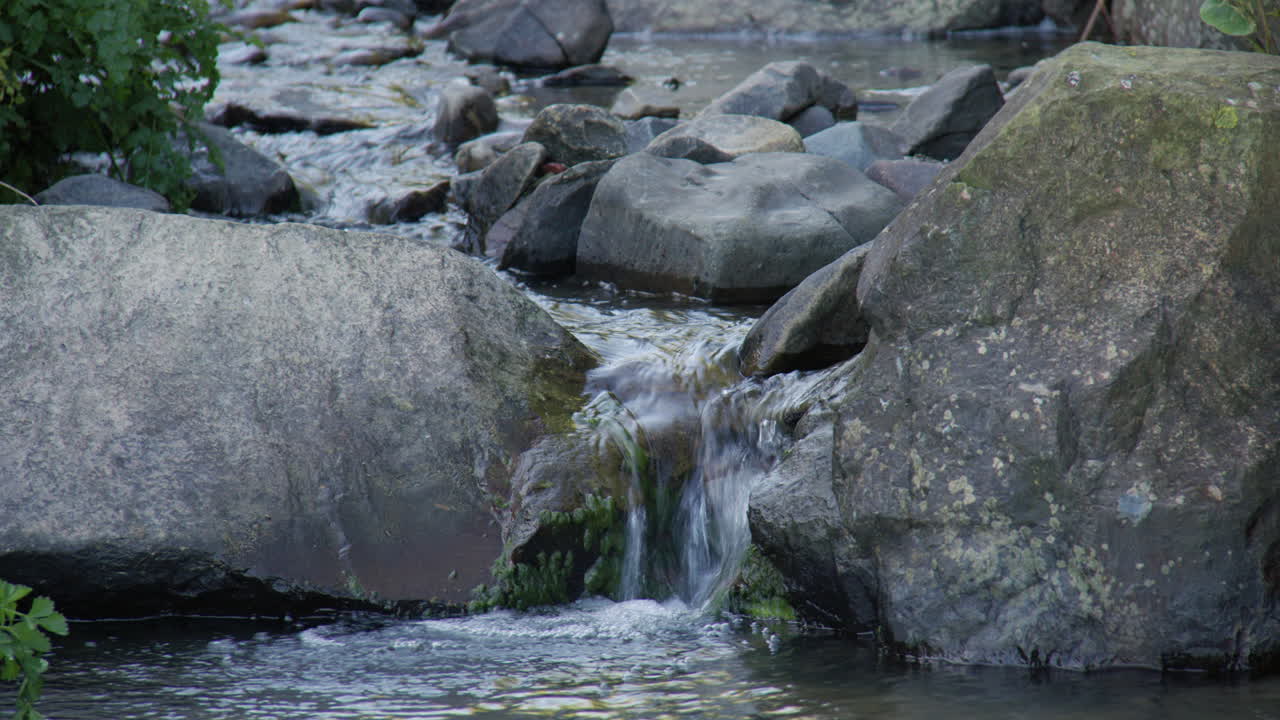shot of water on a small rocky stream brook at new quay beach