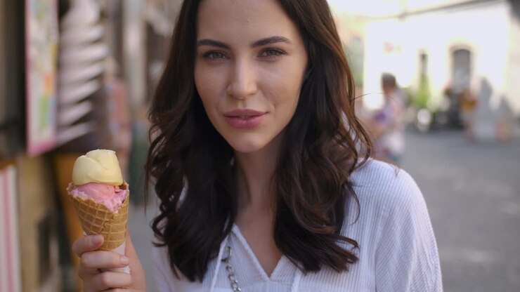 Hermosa mujer morena comiendo un delicioso y dulce helado