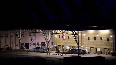 two-helicopters-parked-in-a-hanger-at-night