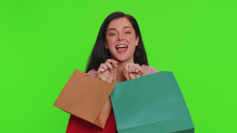 mujer joven mostrando bolsas de compras, descuentos publicitarios, sorprendida con los bajos precios en las fiestas