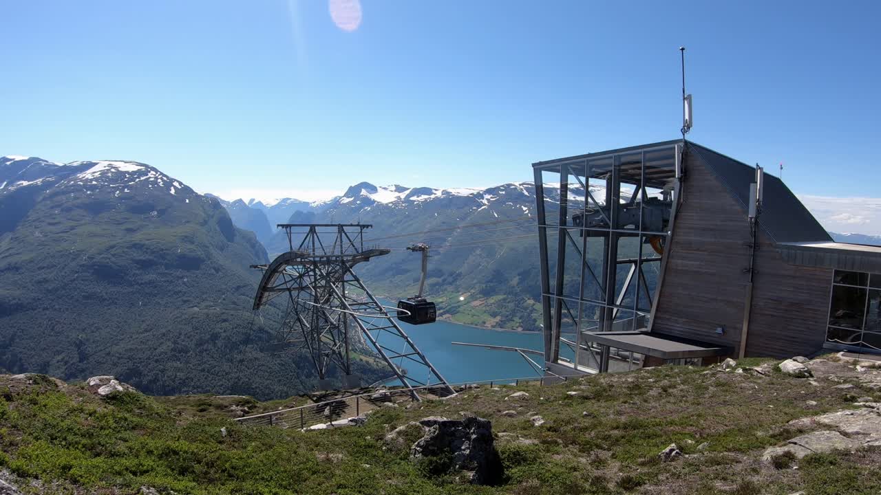 teleférico loen skylift llegando a la estación superior mountain hoven - tiro estático viendo la cabina de la góndola llegando desde la distancia - viendo el mástil y la estación superior con muchas torres celulares instaladas- noruega