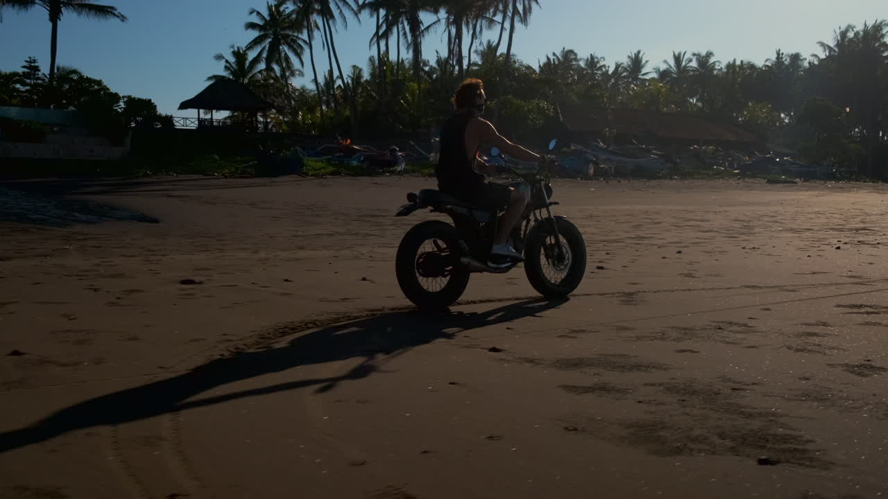 Motorcycle ride on a tropical beach at sunset