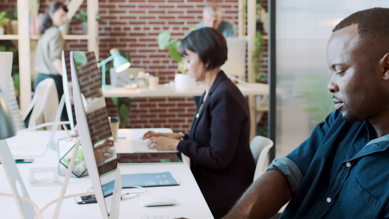 Sort mand, computer og co-working arbejdsplads