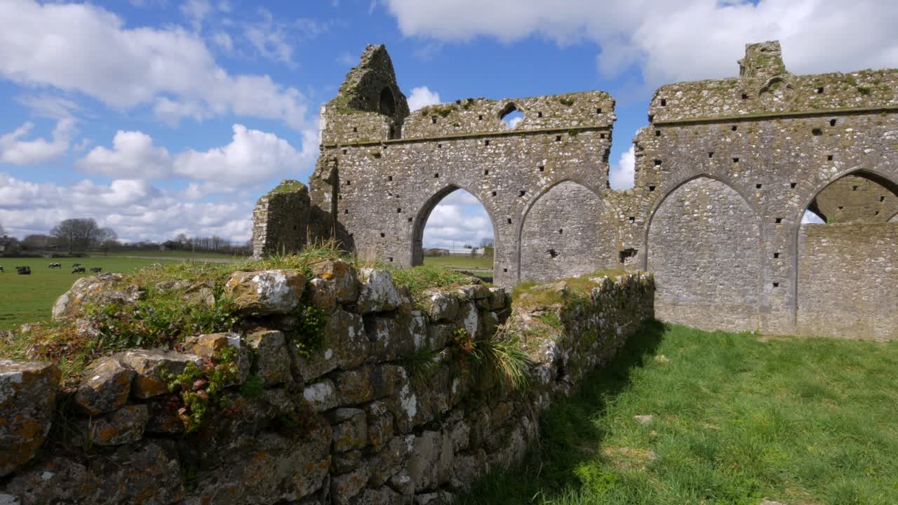 Ancient Ruins in a Green Field under a Cloudy Sky