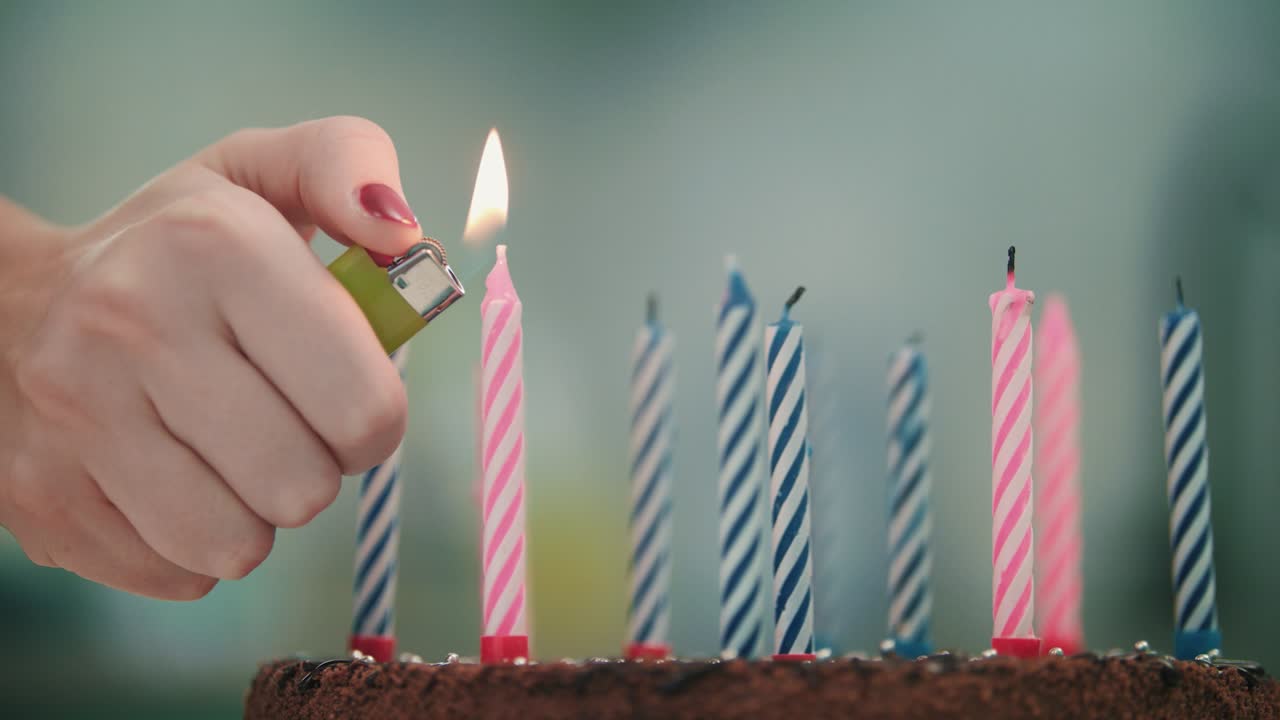 vela encendida de mano femenina en el pastel de cumpleaños. feliz concepto de celebración de cumpleaños