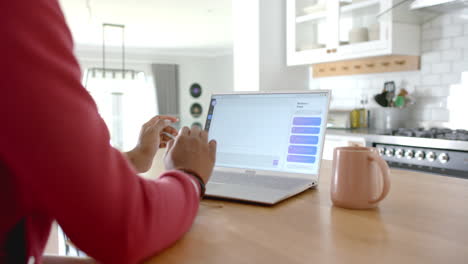 using laptop, woman studying digital marketing with ai chat on kitchen table
